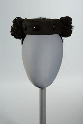 Black pillbox hat with veil and pom poms